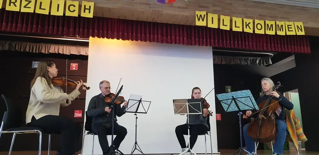 Streichquartett mit Geigen und Cello spielt auf der Bühne der Aula