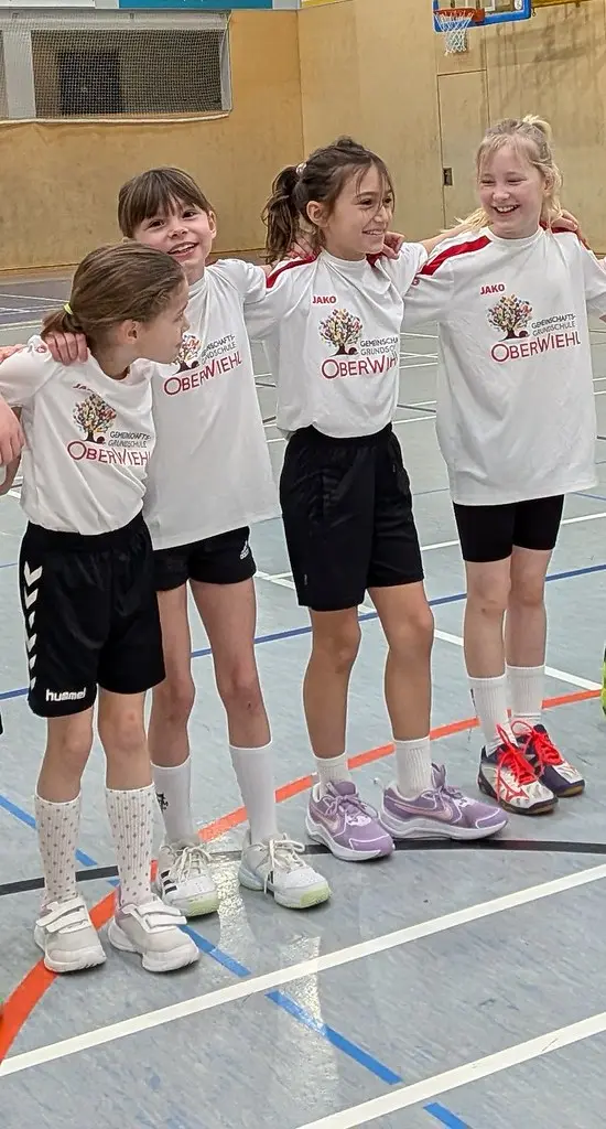 Vier Kinder im Oberwiehler Trikot stehen Arm in Arm in der Halle