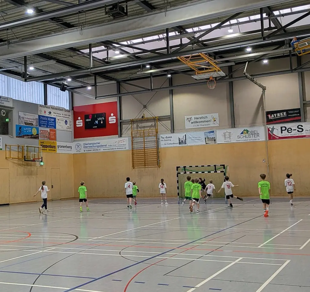 Blick über die Sporthalle auf ein laufendes Spiel mit Anzeigetafel