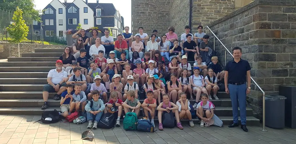 Große Gruppe Kinder und Erwachsene beim Gruppenfoto auf einer Steintreppe