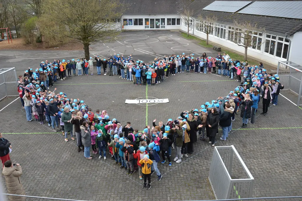 Kinder und Erwachsene im Herz, viele formen die Hände zu einem Herz