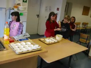 Kinder formen in der Schulküche Teigstücke auf einem Backblech