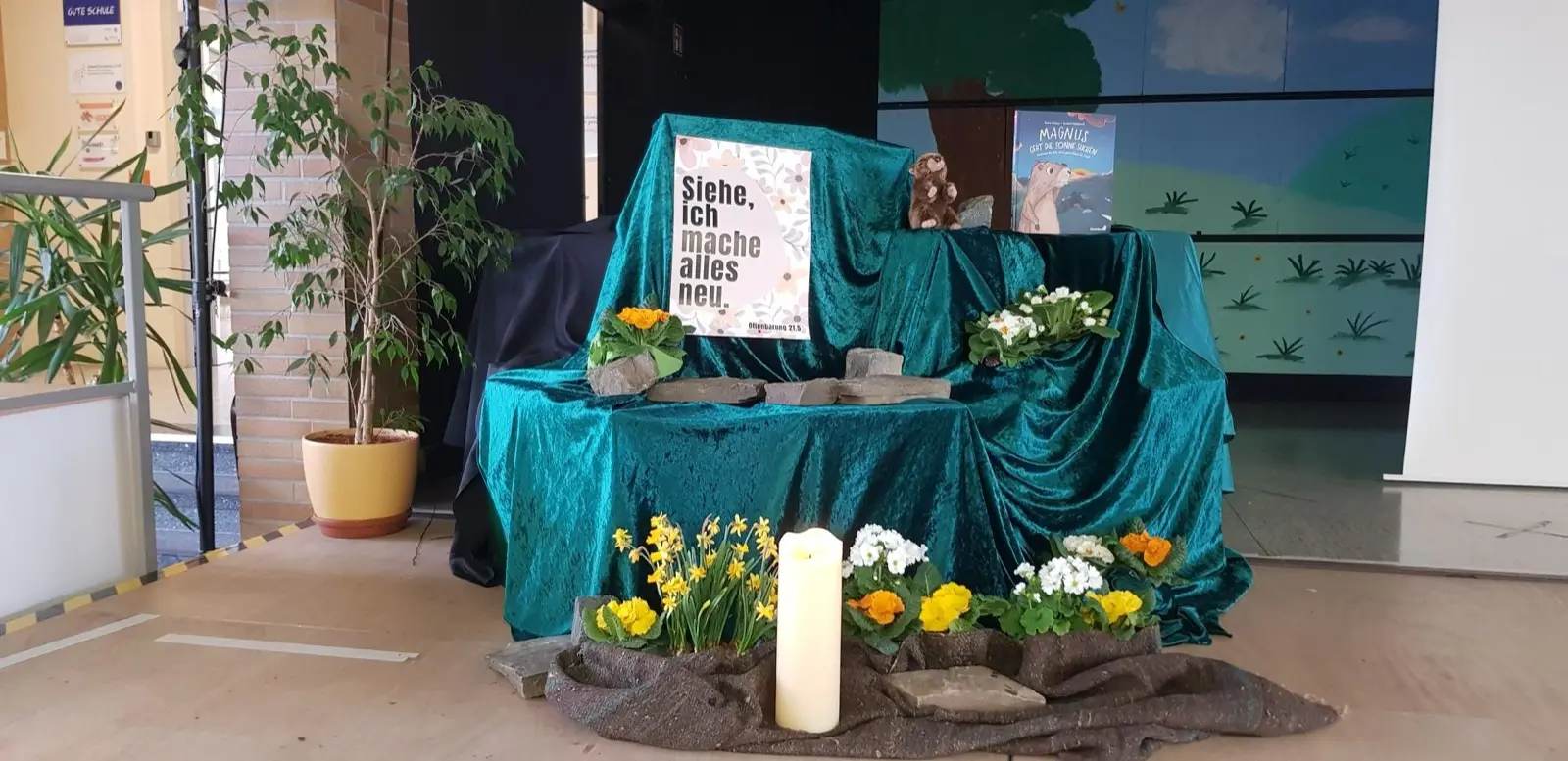 Ein festlich geschmückter Altar mit Blumen und Kerze zum Ostergottesdienst in der Schule