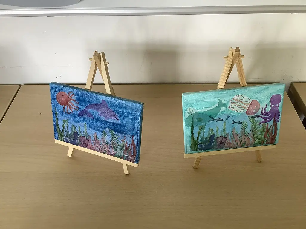 Zwei gemalte Unterwasserbilder mit Delfin, Krake und Qualle auf Staffeleien