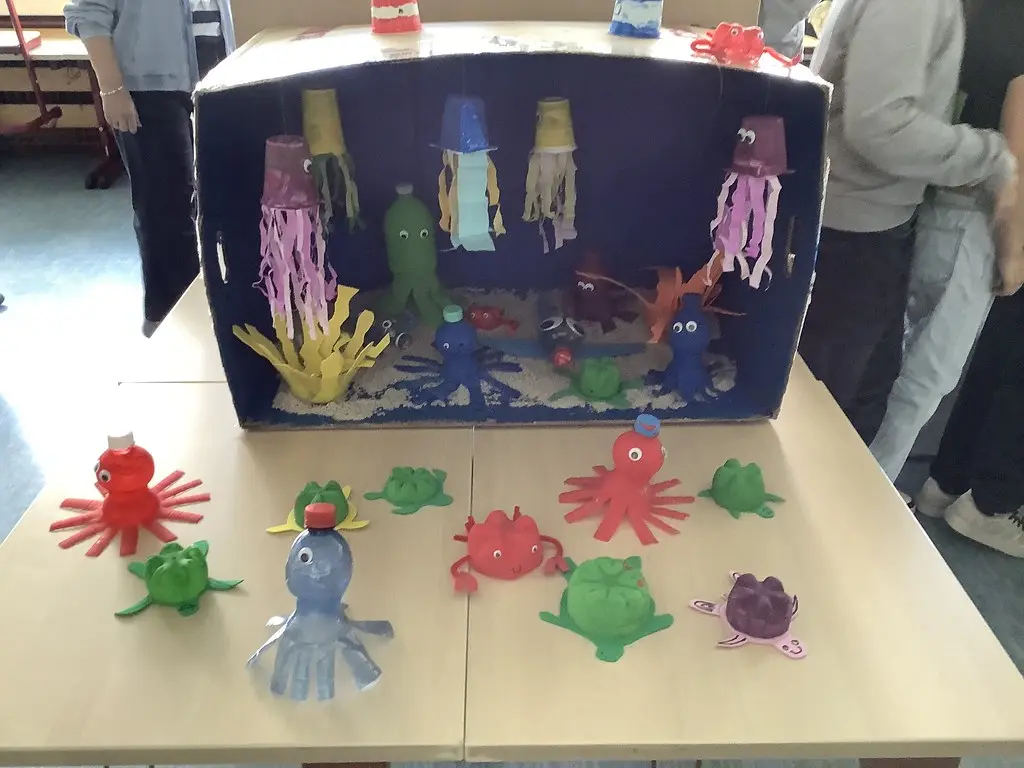 Unterwasser-Diorama aus Karton, davor Kraken, Krabben und Schildkröten aus Recyclingmaterial
