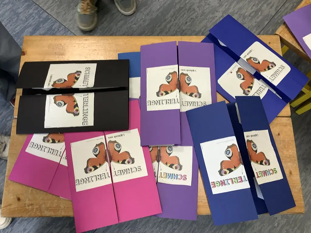 Bunte Lapbooks zum Thema Schmetterlinge liegen auf einem Tisch